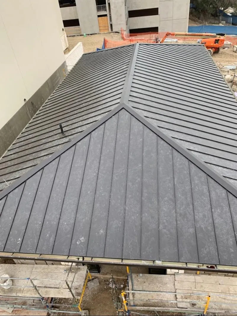 Commercial metal roof construction with crane equipment in Cottleville